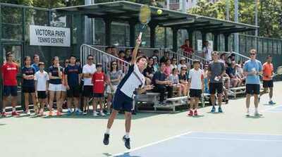 Junior boy hitting serve at Victoria Park