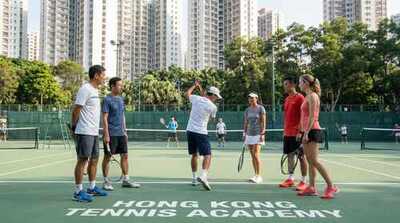 Coach teaching serve technique at Victoria Park